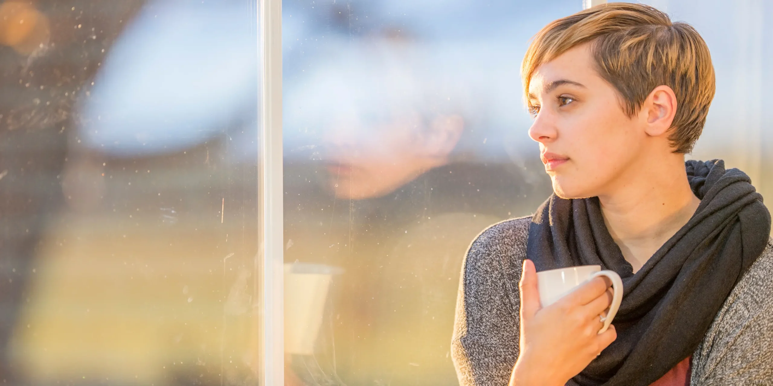 Mental health support and guidance in Hamilton - young woman reflecting while holding a cup
