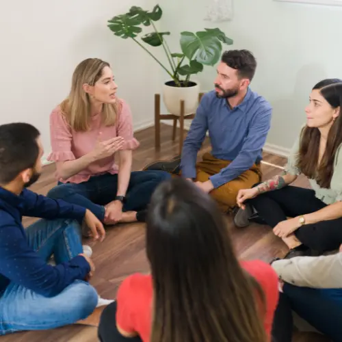 Group counseling session with people sitting in a circle discussing mental health in Hamilton, Ontario