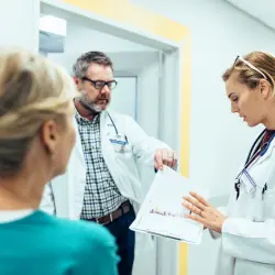 Doctors discussing mental health treatment options with a patient in a hospital hallway - mental health support, navigating the healthcare system, accessing treatments.